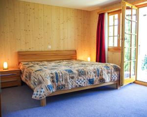a bedroom with a bed and a large window at Chalet Charis in Bellwald