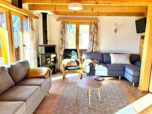 a living room with two couches and a stove at Chalet Charis in Bellwald