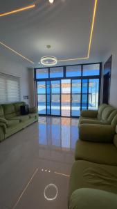 a living room with two couches and a room with windows at سبانا شاليه in Jerash
