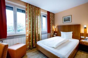ein Schlafzimmer mit einem großen Bett und zwei Fenstern in der Unterkunft Hotel Alter Kranen in Würzburg + 71 Fotos