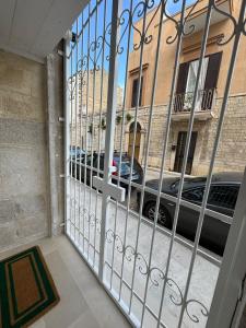 a gate with a car parked in front of a building at Dimora Antica Santa Chiara in Trani