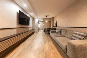 a living room with a couch and a flat screen tv at The Mita Villa - 2 bed rooms & 3 floors villa with roof garden in Tokyo