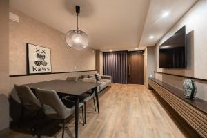 a dining room with a table and a couch at The Mita Villa - 2 bed rooms & 3 floors villa with roof garden in Tokyo