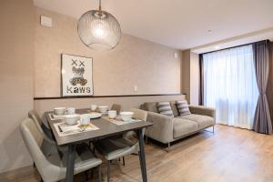 a living room with a table and a couch at The Mita Villa - 2 bed rooms & 3 floors villa with roof garden in Tokyo