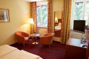 ein Hotelzimmer mit Bett und Fernseher in der Unterkunft Hotel Alter Kranen in Würzburg