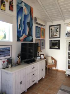 a living room with a television on a white cabinet at Casa Brisa do Mar in Comporta