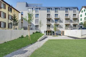 a tree in front of a building at MOOI Apartments Biel in Biel