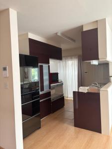 a kitchen with dark brown cabinets and a kitchen island at Riverside Garden -kumanokodo-chikatsuyu- in Tanabe +13 photos
