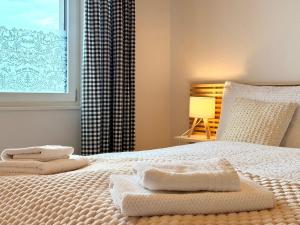 a bedroom with a bed with two towels on it at Modernes Apartment - Lakeview Sunnmatte in Leissigen