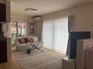 a living room with a couch and a window at Riverside Garden -kumanokodo-chikatsuyu- in Tanabe