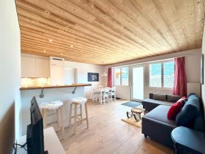 a living room with a couch and a kitchen at Modernes Apartment - Lakeview Sunnmatte in Leissigen