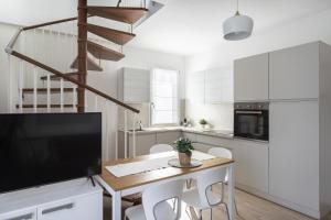 a kitchen with a table with chairs and a television at Maison Bellini 4 in Toscolano Maderno
