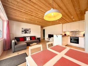 a living room with a couch and a table at Modernes Apartment - Lakeview Sunnmatte in Leissigen