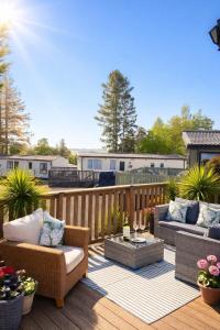 a patio with couches and tables on a wooden deck at Travellers Rest Retreat in Oxnam