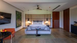 a bedroom with a bed and a couch and a table at Amaaranth Goa in Varca +27 photos