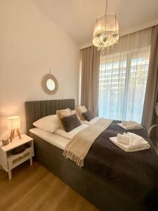 a bedroom with a large bed and a chandelier at HO!HOUSE SHELLTER ROGOWO in Rogowo