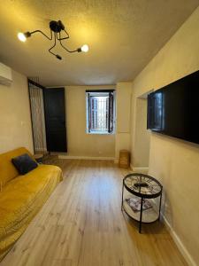 a living room with a couch and a table at Appartement cosy dans les ruelles de Pietranera in San-Martino-di-Lota