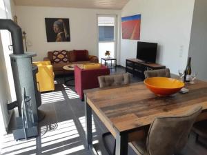 a living room with a wooden table and a wood stove at Ferienhaus Happy Days in Nordhorn +5 photos