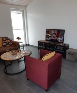 a living room with a couch and a table and a tv at Ferienhaus Happy Days in Nordhorn