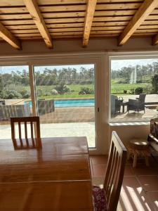 a dining room with a table and a large window at Vila Brisa do Mar in Comporta