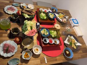 a wooden table topped with different types of food at Riverside Garden -kumanokodo-chikatsuyu- in Tanabe