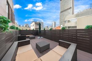 a rooftop patio with benches and a view of the city at The Mita Villa - 2 bed rooms & 3 floors villa with roof garden in Tokyo