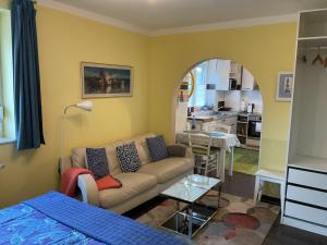a living room with a couch and a kitchen at Ferienapartment Hartung in Heikendorf