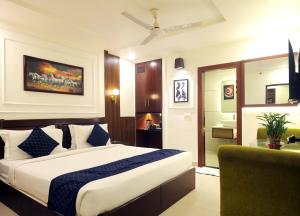 a hotel room with a bed and a chair at Taj Inn Hotel in Agra