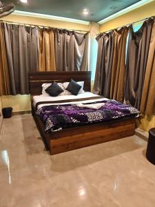 a bed in a room with some curtains at Hotel Heavens in Dum-Dum Junction
