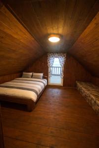 a bed in a wooden room with a window at Chalupa Lipka in Kolárovice