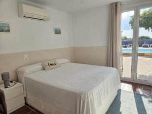 a bedroom with a white bed and a large window at Villa Playa in L'Ametlla de Mar +12 photos