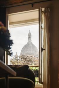 a view of a building through a window at La Bohème Montmartre - Studios & Apartments de luxe au Sacré Coeur in Paris