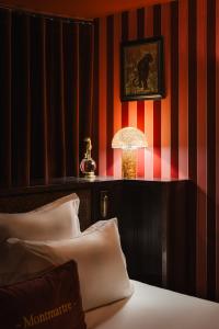 a room with a bed with a lamp and a striped wall at La Bohème Montmartre - Studios & Apartments de luxe au Sacré Coeur in Paris +113 photos