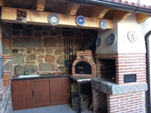 a outdoor kitchen with a brick oven in a house at Casa Abuela Antolina in La Horcajada