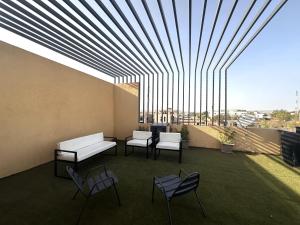 a balcony with chairs and a couch and a table at Villa Solaya in Bamako