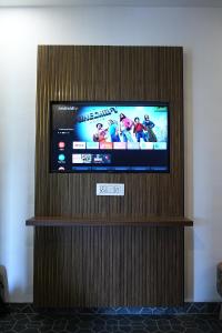 a flat screen tv on a wooden wall at Sundown Resort in Noida