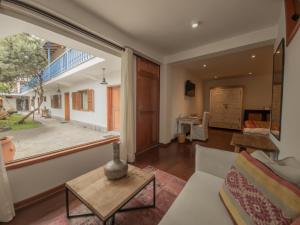 a living room with a couch and a large window at Tocuyeros Boutique Hotel in Cusco
