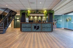 a lobby of a hotel with a reception counter at Fletcher Hotel-Restaurant Paasberg in Lochem