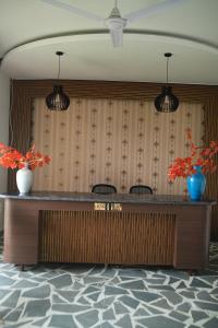 a reception desk with two vases on top of it at Sundown Resort in Noida +126 photos