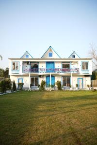 a large white house with a large grass field at Sundown Resort in Noida