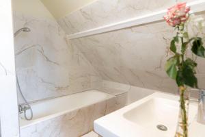 a bathroom with a white tub and a sink at Relais Touraine Sologne in Noyers-sur-Cher