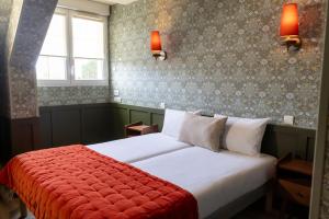 a bedroom with a white bed with a red blanket at Relais Touraine Sologne in Noyers-sur-Cher
