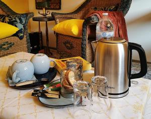 a tea kettle and cups on a table at La Maison d'Eana in Maintenon