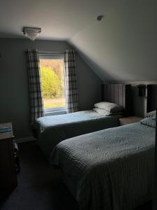 a bedroom with two beds and a window at Campfield House in Fort William