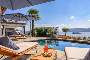 a villa with a swimming pool and a table with a bowl of fruit at Villa Suna Paradiso in Verbania