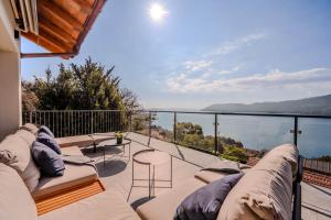 a balcony with a couch and a view of the water at Villa Suna Paradiso in Verbania