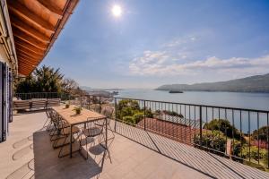 a balcony with a table and chairs and a view of the water at Villa Suna Paradiso in Verbania +48 photos