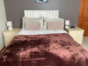 a bedroom with a large bed with two night stands at Cozy Room at Willow House in Leyland