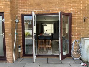 an open door to a patio with a sink at Cozy Room at Willow House in Leyland