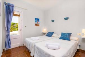 two beds in a white room with blue pillows at Villa Las Rosas by Villa Plus in S'Algar +14 photos